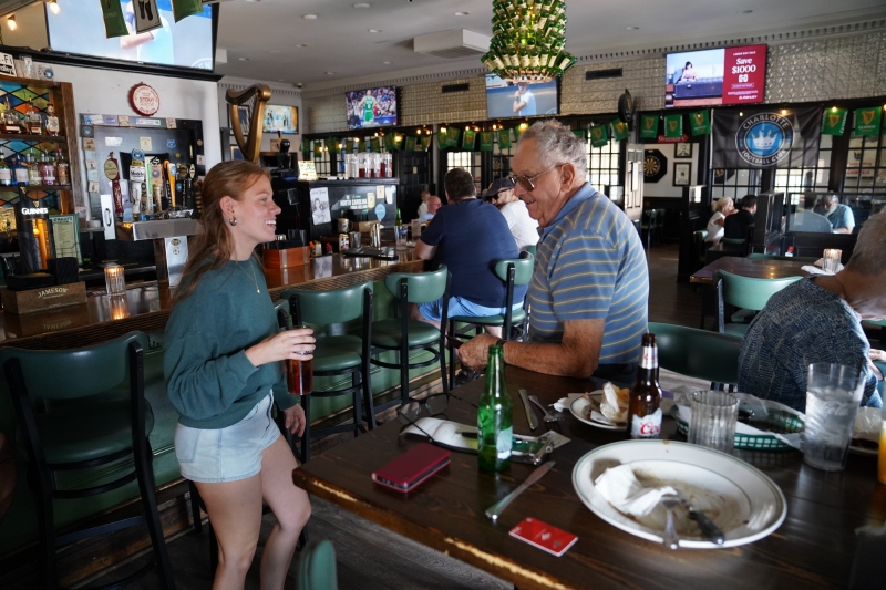Vernon joking with the young waitress while Janice looks the other way